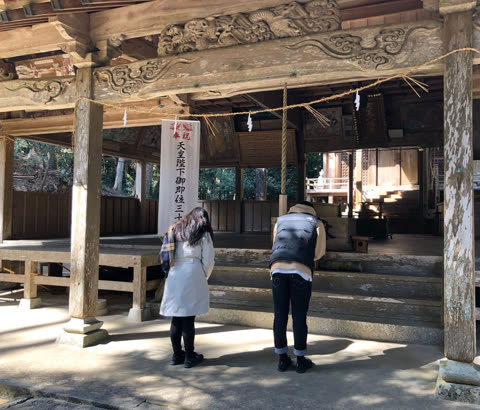 Two people bowing at a temple.